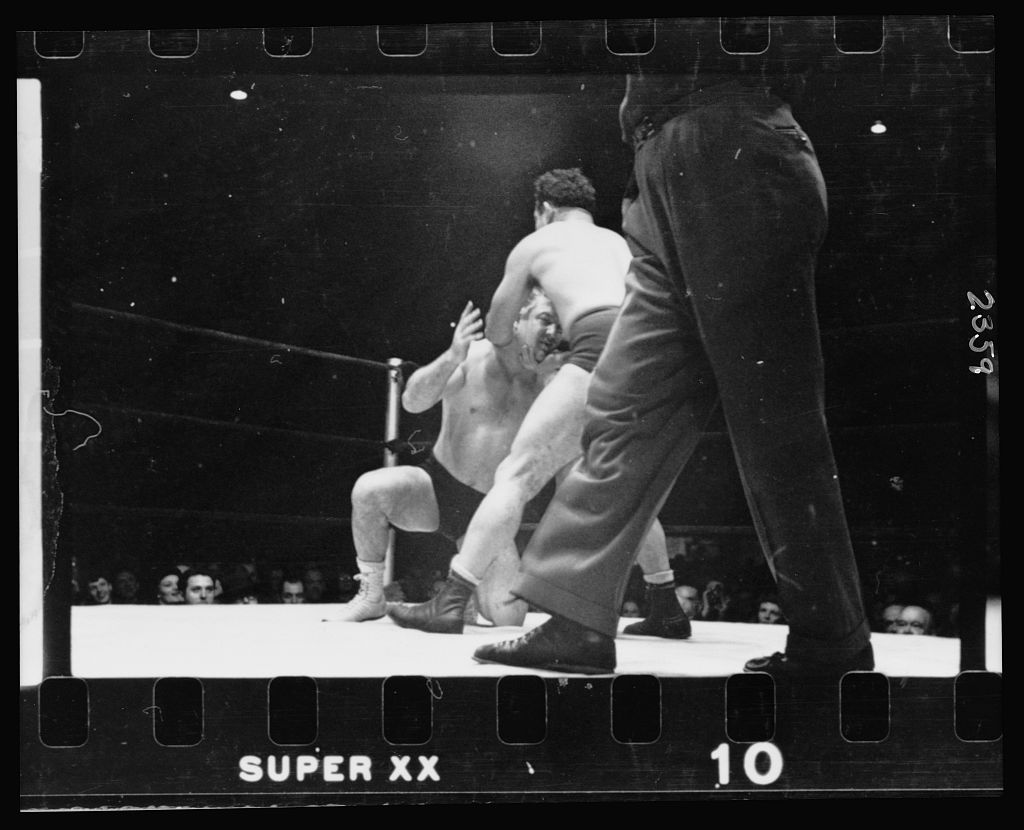 A wrestler holding Gorgeous George by the chin, 1949.