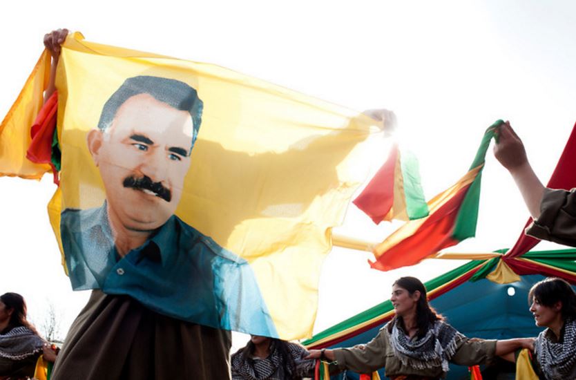 Kurdish fighters hold a banner with the image of PKK leader Abdullah Öcalan. KurdekiBenav / Flickr
