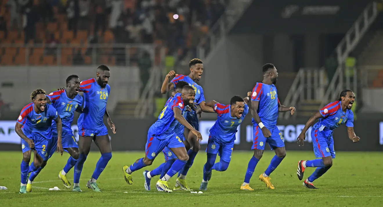 DR Congo national team players run and celebrate after defeating Egypt on penalties at the 2023 AFCON.