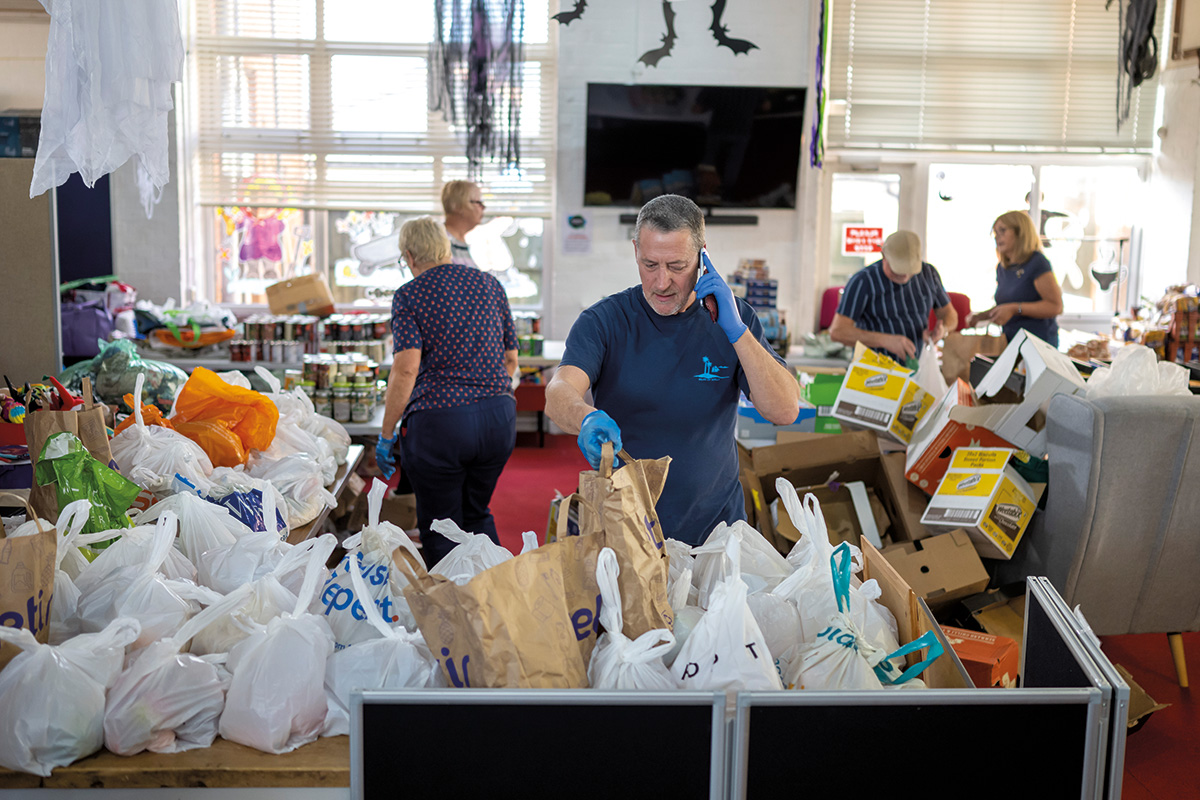 Volunteers sort food into food parcels at the Rumney Forum community charity.
